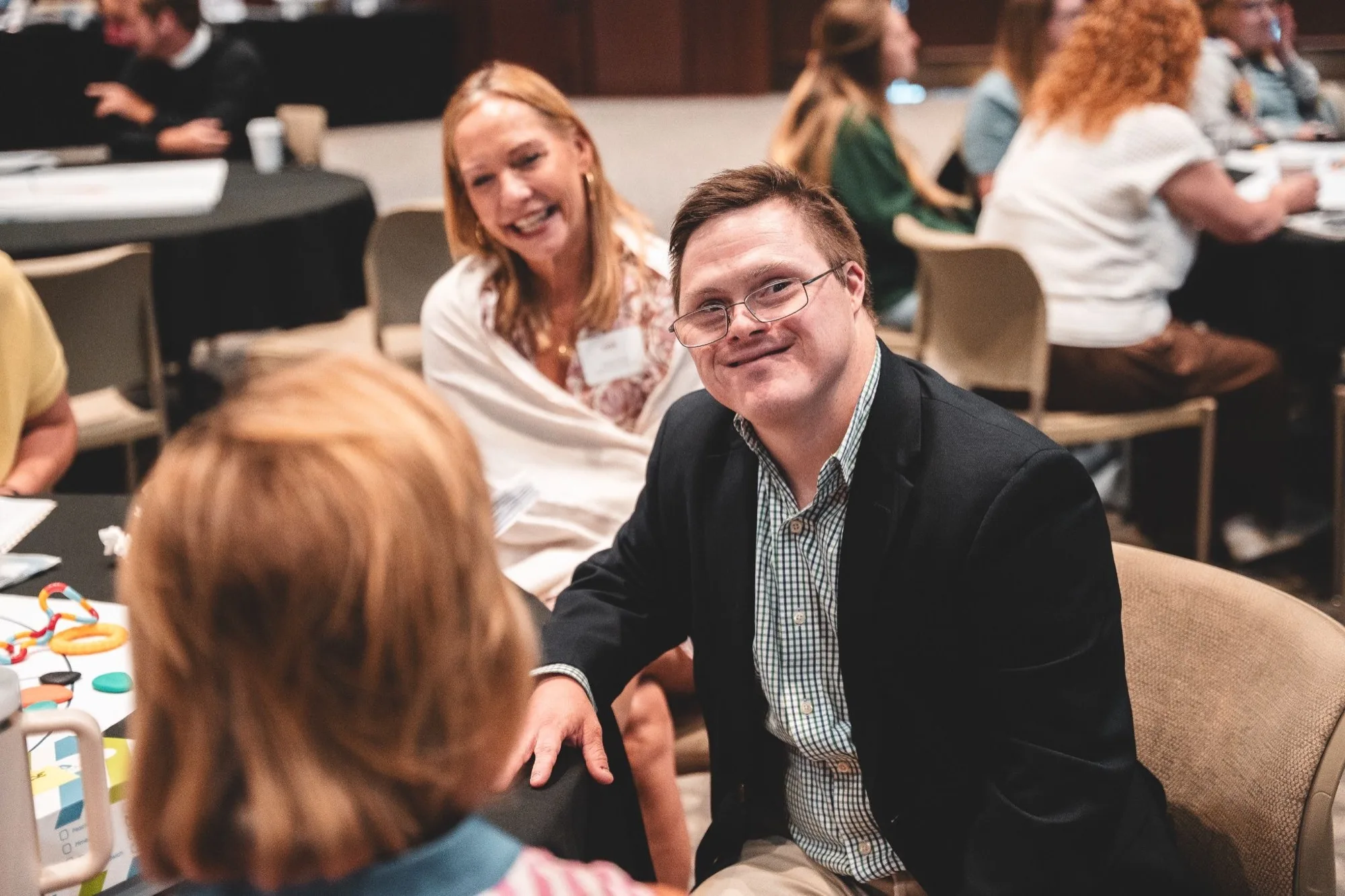 Smiling young man at a Worship As One summit table